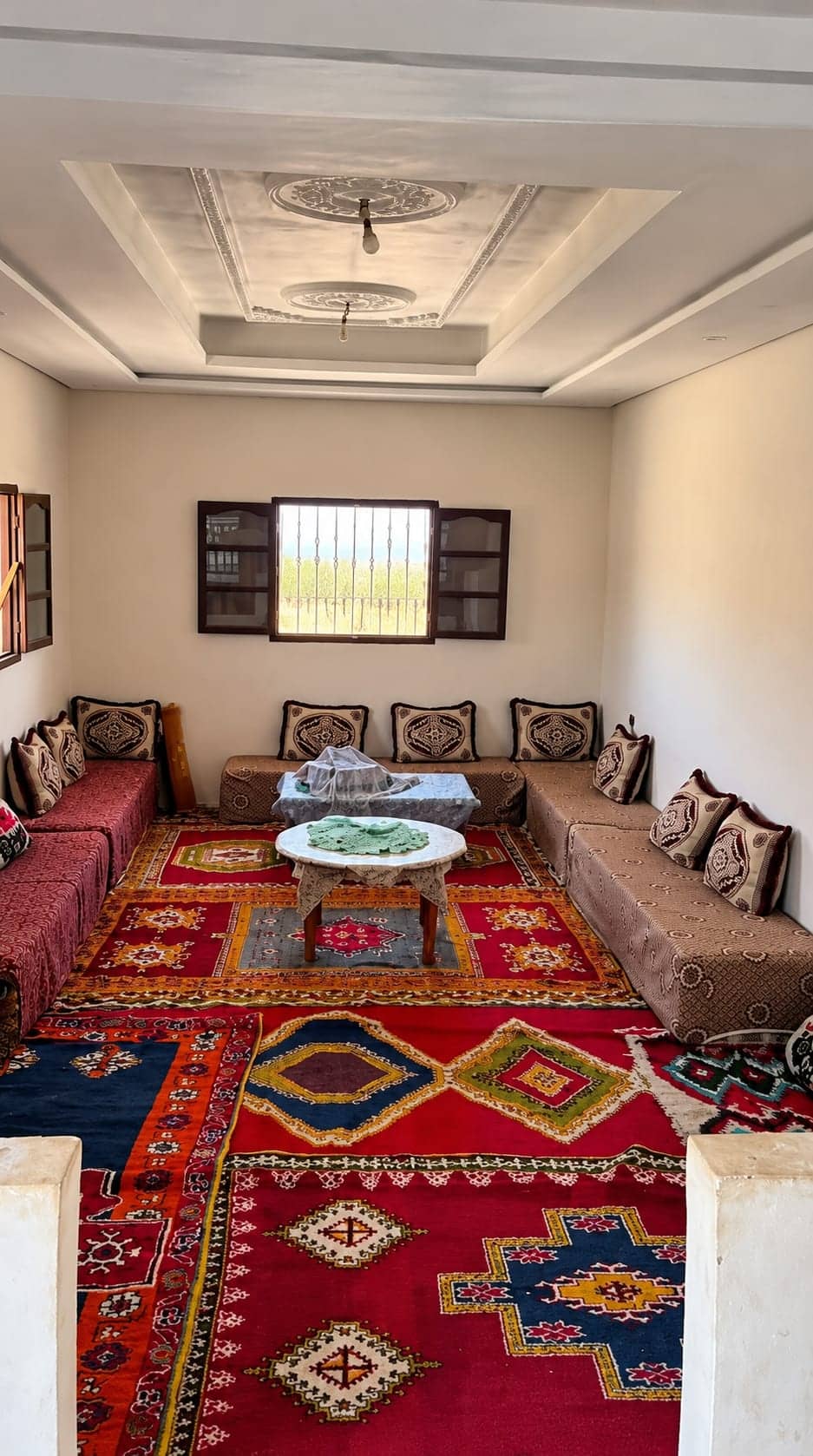 Salon de la maison, banquettes et tapis, espace pour s'asseoir en famille