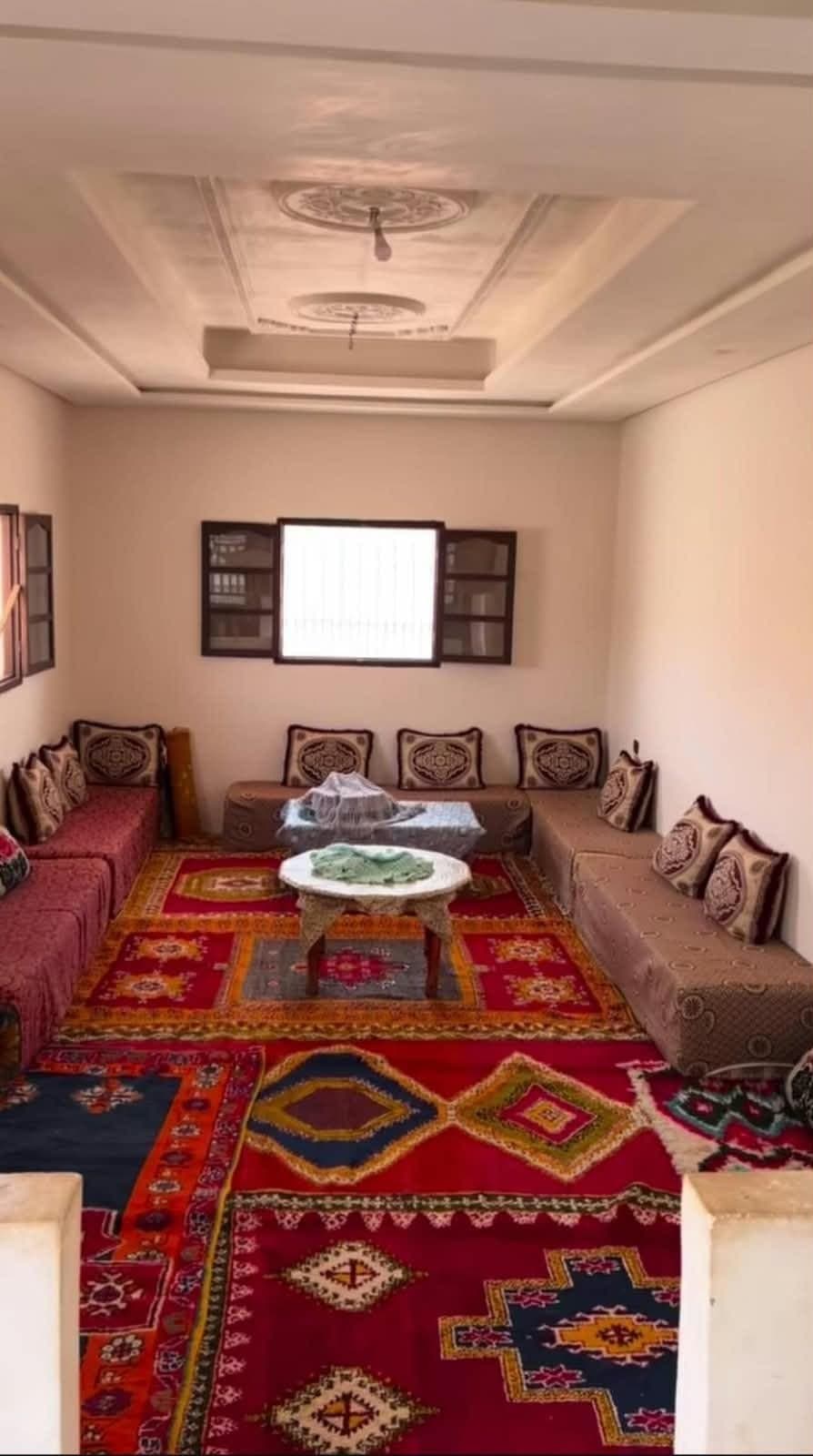 Salon aux tapis amazighs et banquettes